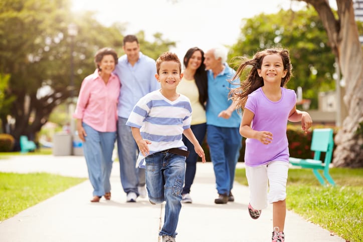 Multi Generation Family Walking In Park Together